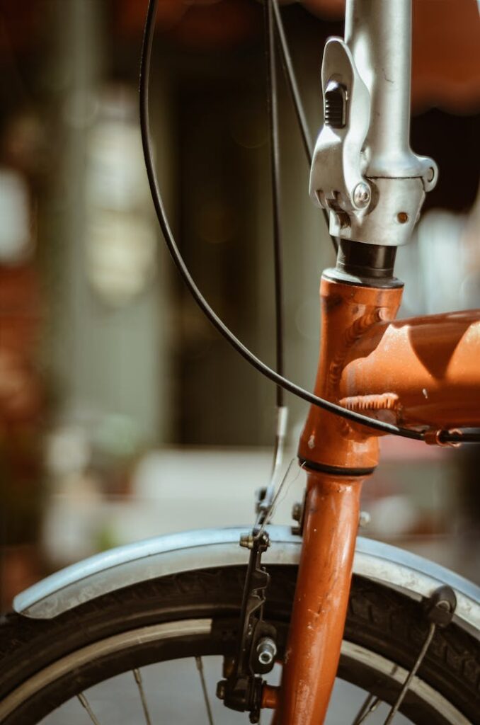 Detailed close-up of a vintage bicycle's fork and front wheel outdoors.